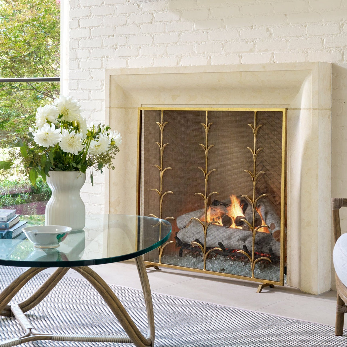 Lily Stems hand-forged fireplace screen fitted to a stone firebox