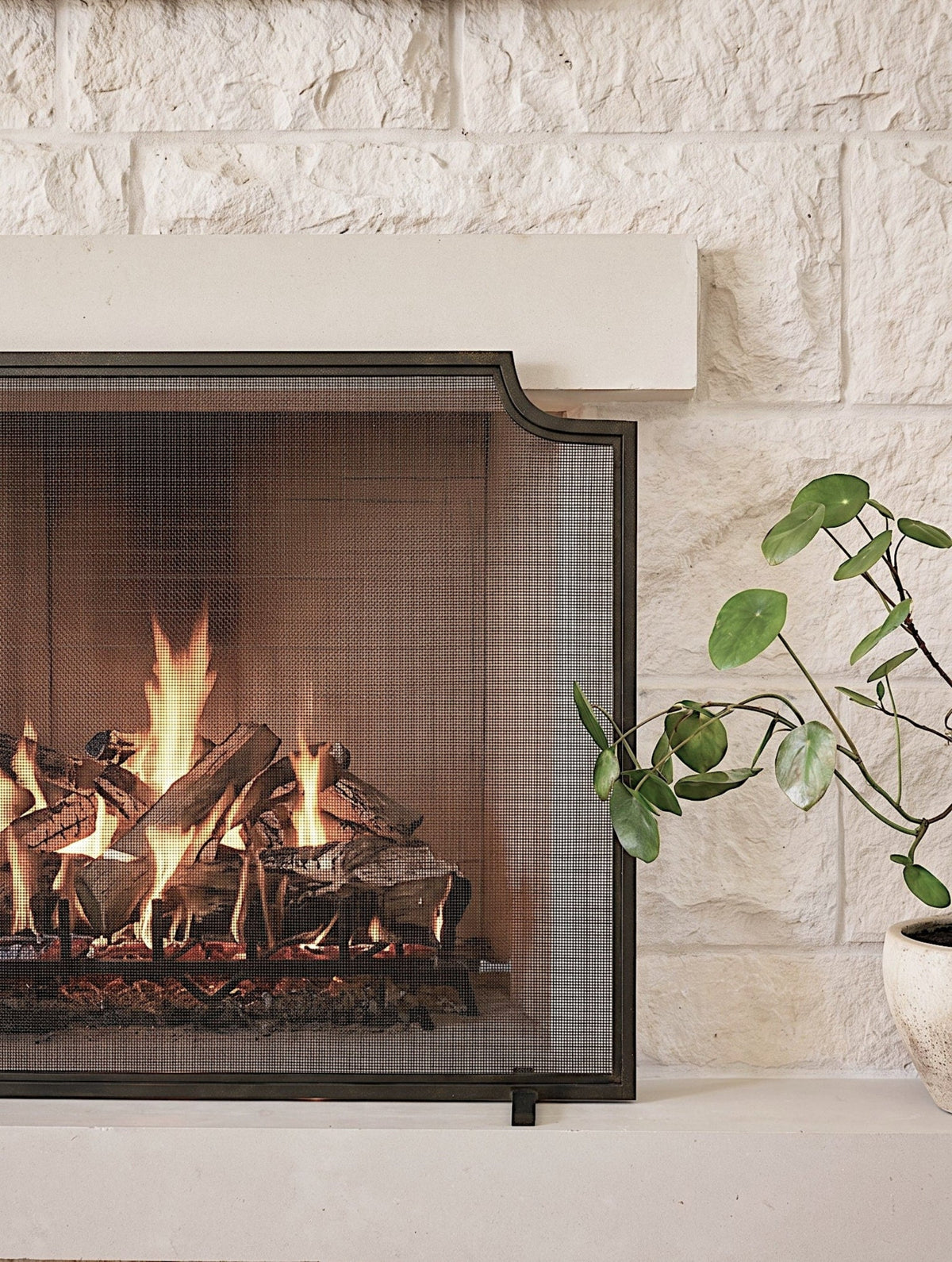 Custom Linden fireplace screen installed at a stone hearth