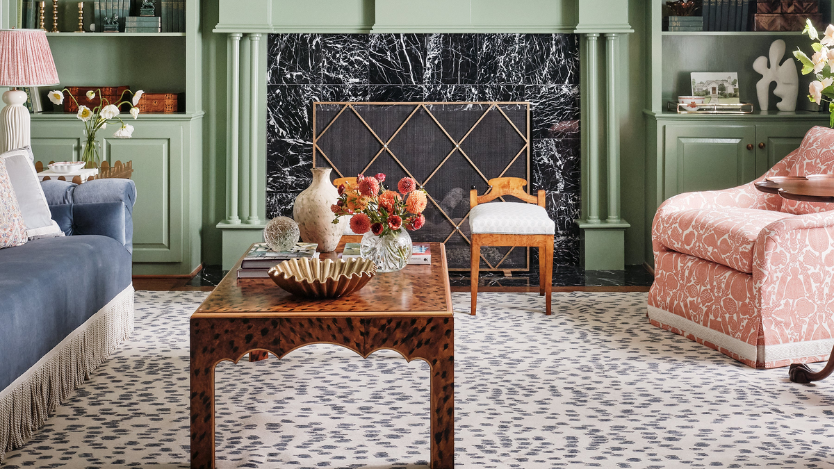 Geometric fireplace screen at a black marble fireplace in a room with green millwork.