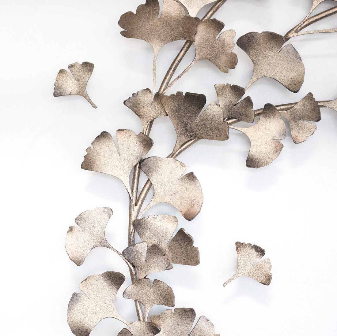 Detail of handcrafted ginkgo wall sculpture in aged silver, adding organic elegance and nature-inspired metal wall art to a modern interior.